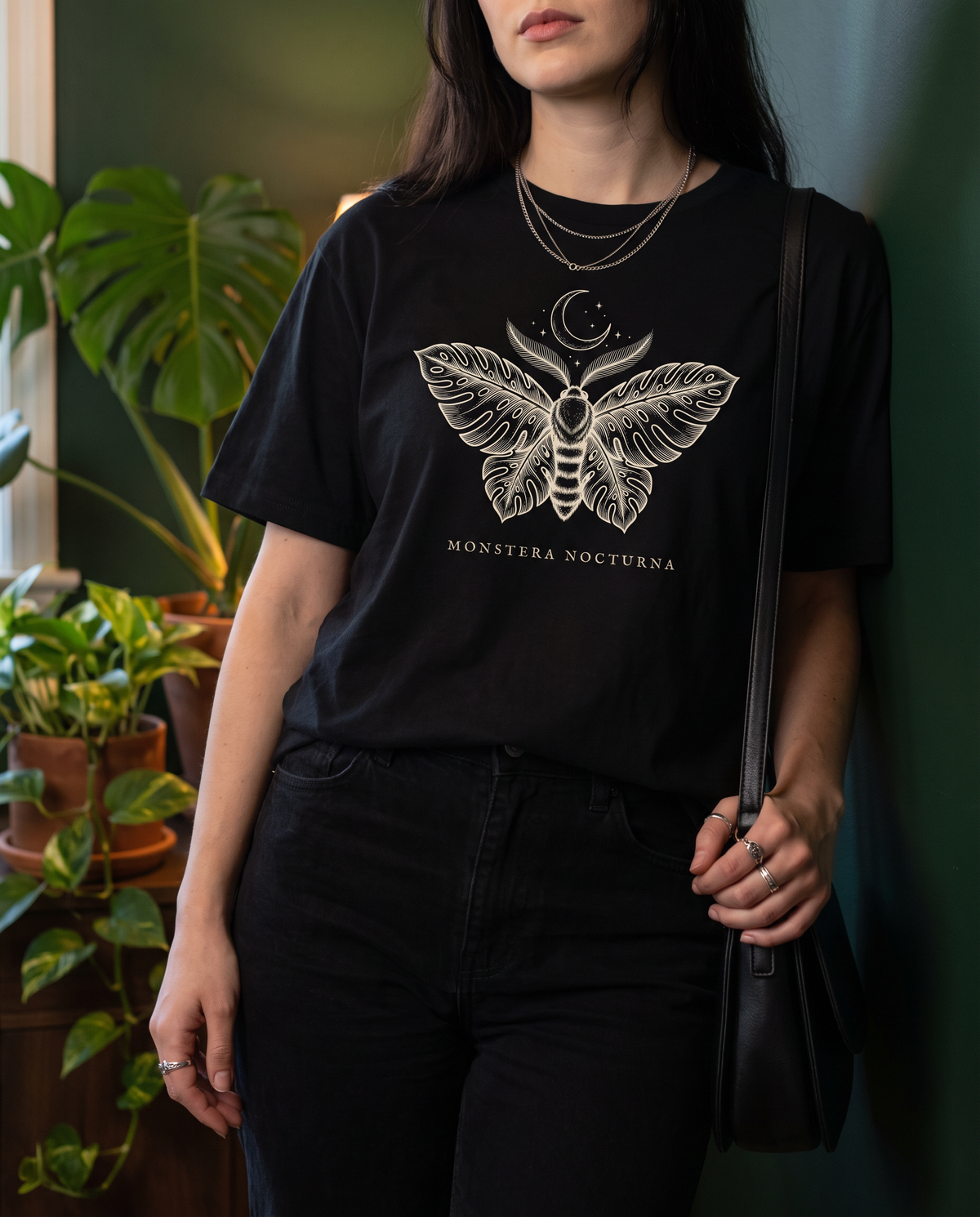 Woman wearing the Monstera Nocturna moth tee in Black