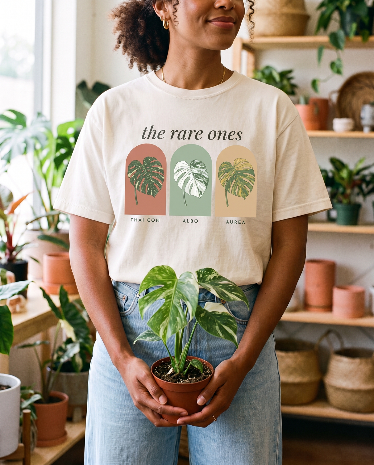 Woman holding a monstera, wearing The Rare Ones tee in Ivory