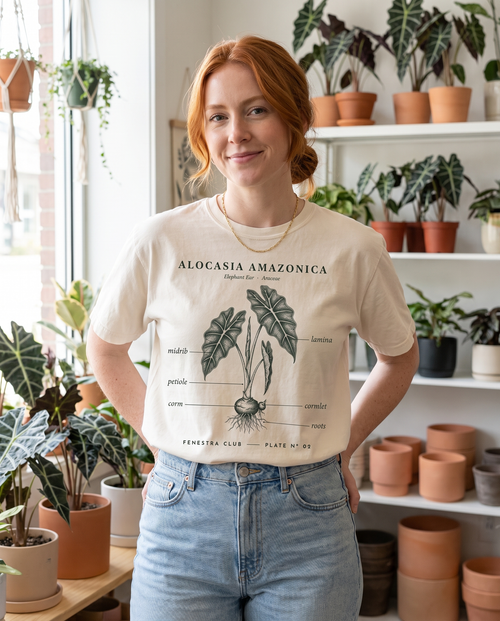 Woman in a plant shop wearing the Alocasia Plate Nº 02 tee in Ivory